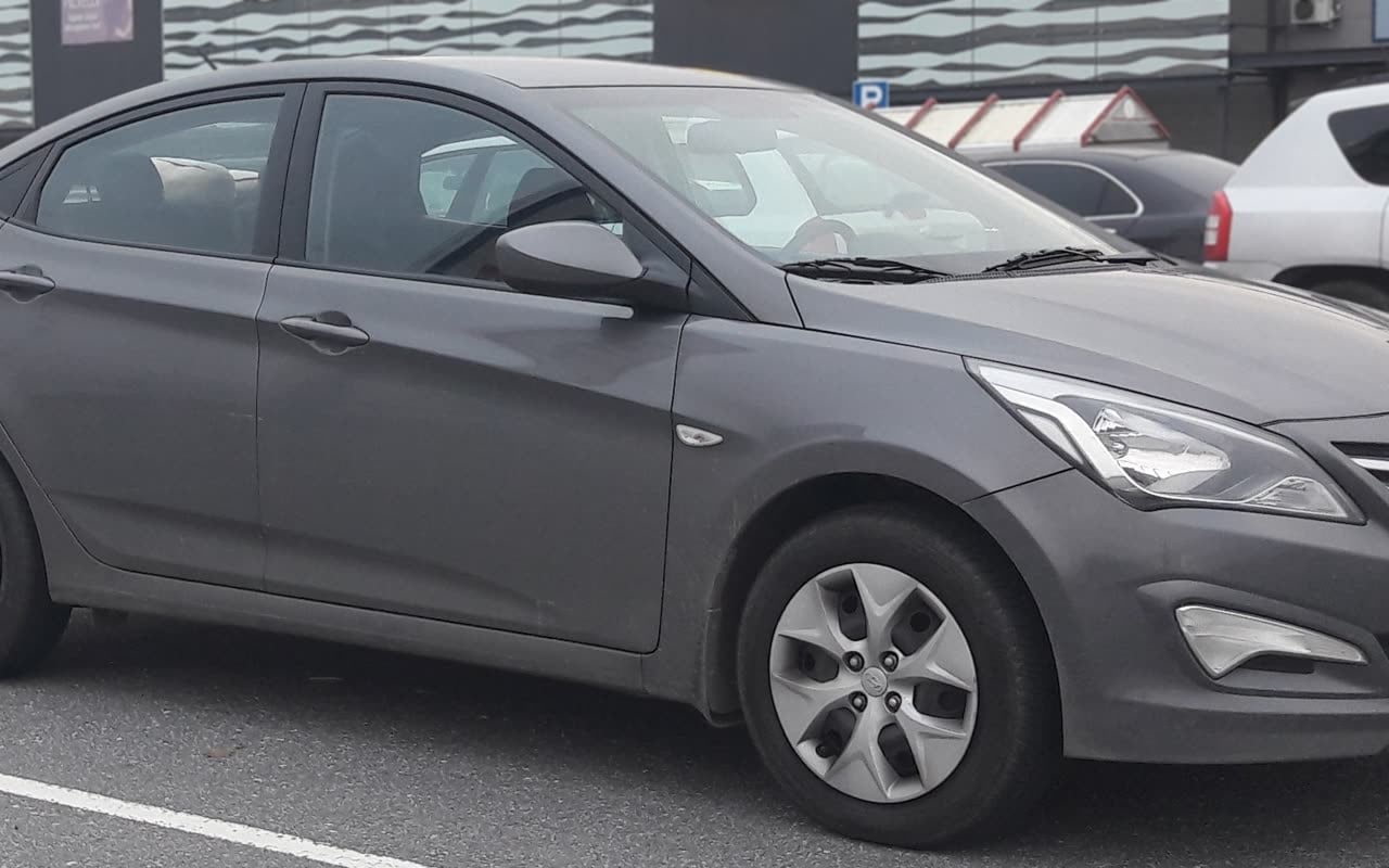 Серый Hyundai Solaris на парковке, вид сбоку