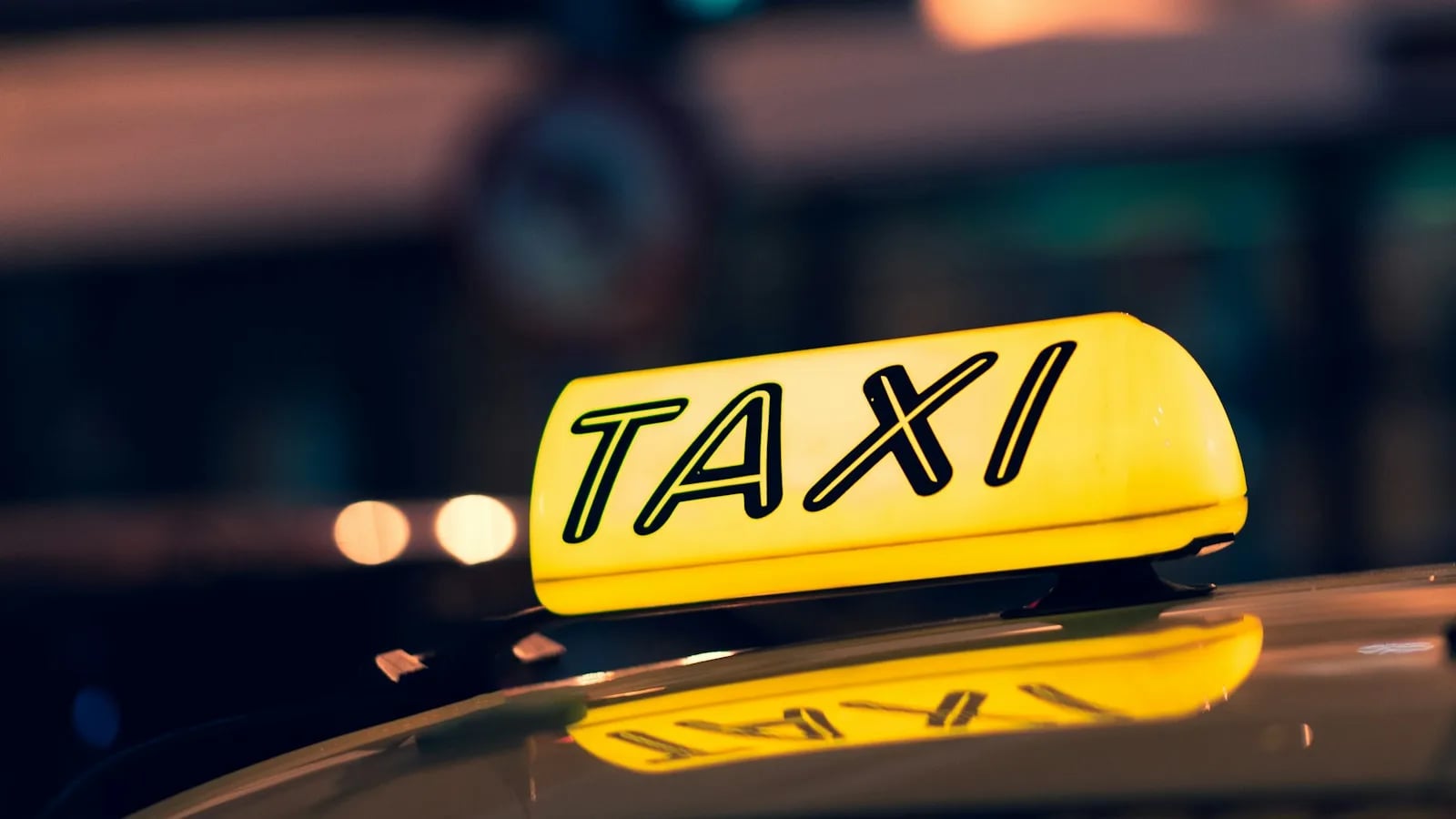 Табличка «Taxi» на крыше автомобиля ночью